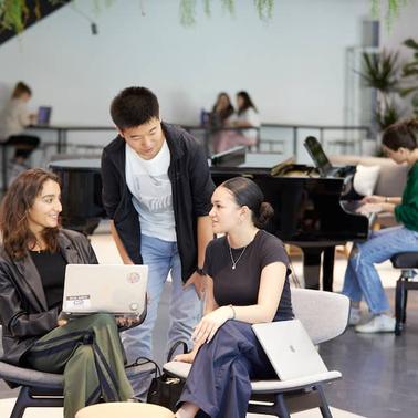 A group of young adults engaged in conversation in a stylish indoor space.