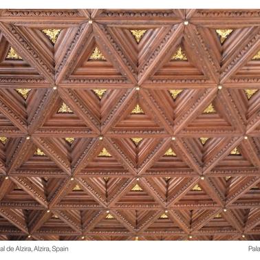 The ornate wooden ceiling of Casa Consistorial de Alzira features intricate triangular patterns.