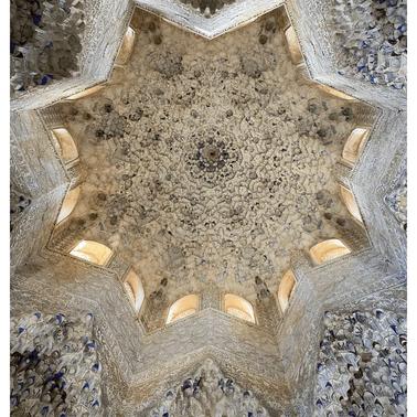 The intricate ceiling of the Hall of the Two Sisters in the Alhambra, adorned with detailed geometric patterns.
