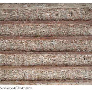 A view of a rustic wooden ceiling with a woven texture.