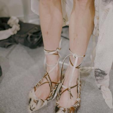 The image shows a pair of unique, stylish shoes with a distinctive design.