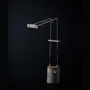 A modern desk lamp with a unique balancing design, featuring a vertical metal structure and wooden details.