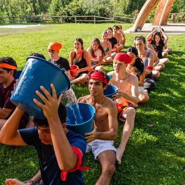 A group of young people participating in a fun outdoor water game.
