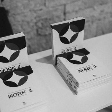 A display of books titled 'WORK 1' arranged on a table.