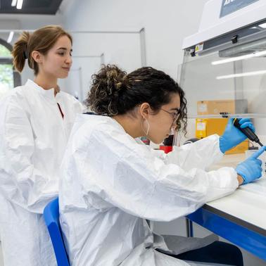 Two women in lab coats working in a modern laboratory setting.