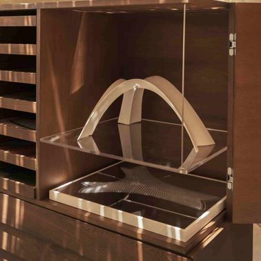A modern display cabinet showcasing an abstract sculpture and a flat design piece.