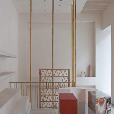 A modern, minimalist interior of a room with decorative shelves, large windows, and stylish furniture