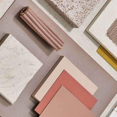 An array of textured tiles and material samples in a coordinated palette of pinks and neutrals.