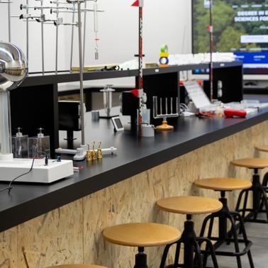 A modern laboratory workspace equipped with various scientific instruments and seating.