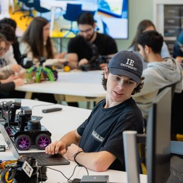 A group of students working collaboratively on robotics projects in a modern classroom.
