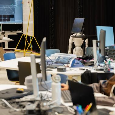 A collaborative workspace with two individuals working on computers in a modern environment.