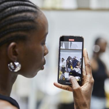 A woman taking a photo with her smartphone at an event.