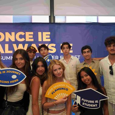 A group of young people posing together with signs related to their educational journey.