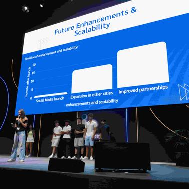 A presenter discusses future enhancements and scalability while standing in front of a chart on stage.