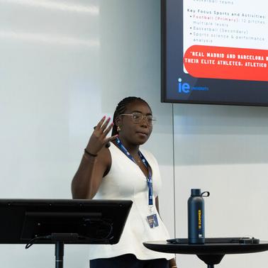 A woman is giving a presentation in a classroom setting.