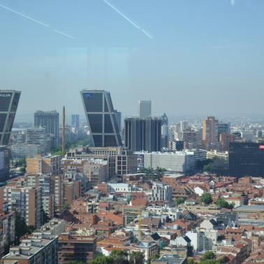 A panoramic view of a city skyline featuring modern buildings and a clear sky.