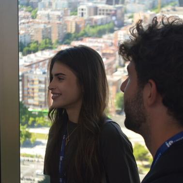 Two people are enjoying a scenic view from a high-rise building window.