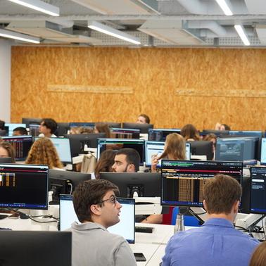 A busy classroom filled with students working at computer stations.