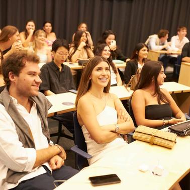 Diverse group of students attentively listening in a classroom setting.