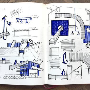 An open notebook containing detailed architectural sketches and notes, predominantly in blue ink.