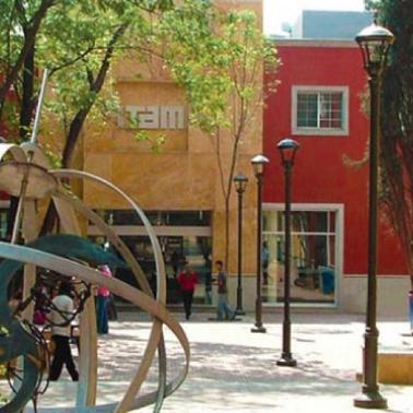 A vibrant urban park featuring colorful buildings, artistic sculptures, and pedestrians enjoying the setting.