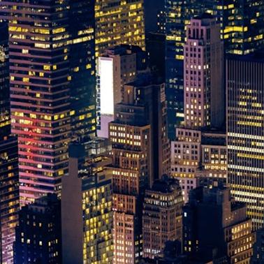 The image shows a vibrant cityscape at night with illuminated skyscrapers.
