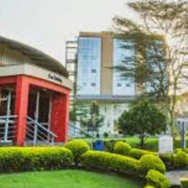 A modern educational building with landscaped gardens in the foreground.