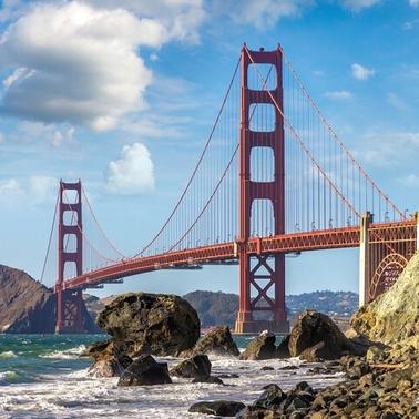A majestic view of the Golden Gate Bridge against a backdrop of clouds and water.