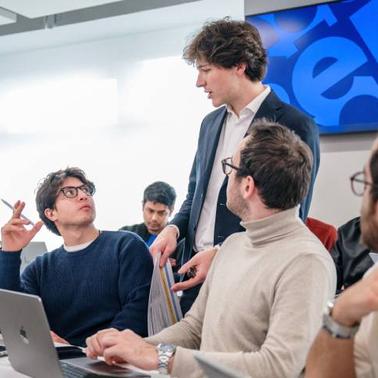 A group of students engaged in a discussion in a modern classroom.