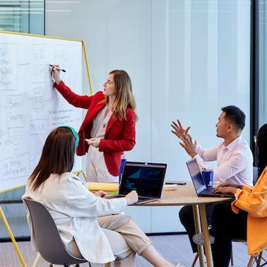 A diverse group of professionals engaged in a presentation in a modern office setting