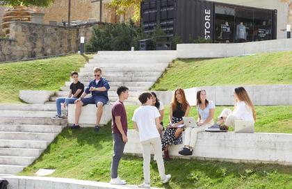 IE Students ousie at the Segovia campus nin a sunny day
