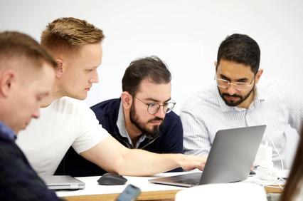 A group of colleagues collaborating at a workstation.