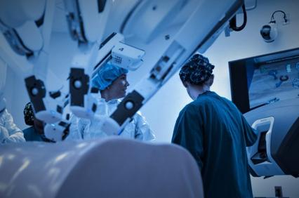 Medical professionals operating advanced robotic machinery in a surgical room.