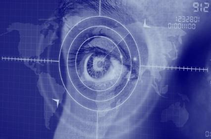An eye overlaid with digital interfaces on a blue map background, symbolizing modern surveillance or data analysis.