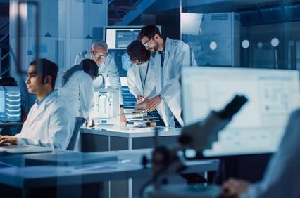 A group of scientists collaborating in a modern laboratory, analyzing data and discussing over a microscope.