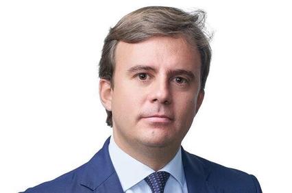 A man in a suit with a neutral expression.