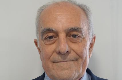 A professional-looking older man with gray hair wearing a suit and tie.