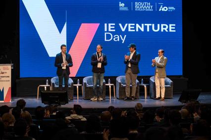 A group of speakers standing on stage at the IE Venture Day event.