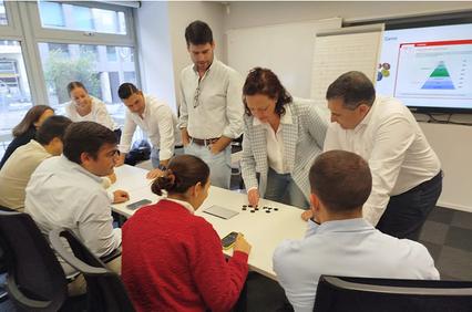 A group of professionals engaged in a collaborative workshop around a table.