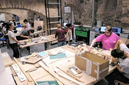 A group of people working on various projects in a creative workshop.