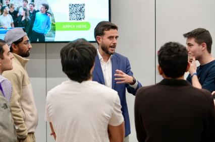 A group of people engaged in a discussion with a speaker in a professional setting.