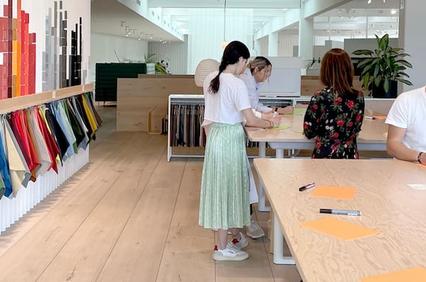People examining and selecting fabrics in a modern textile shop.