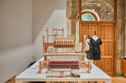 A weaving loom setup in a bright, artistic workspace.