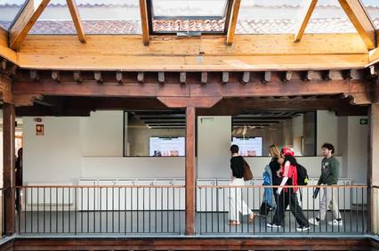 A group of people walking through a wooden structure with an open ceiling and modern interior.