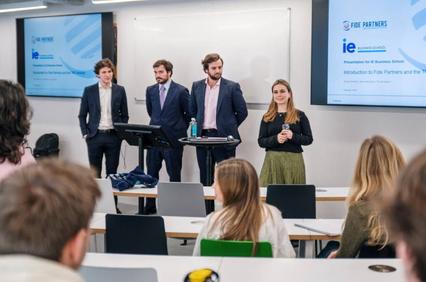 A group of presenters standing in front of an audience in a classroom setting.