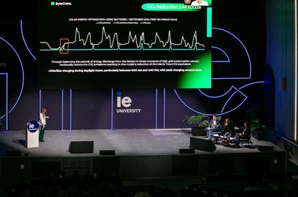 A presentation at IE University discussing solar energy optimization using batteries.