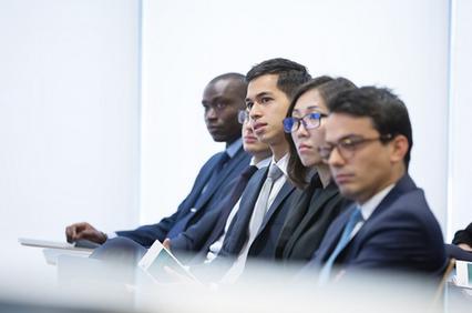 A group of diverse professionals attentively listening during a meeting.