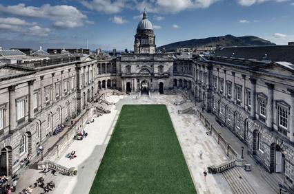A view of a grand classical building with an open courtyard, under a clear sky.