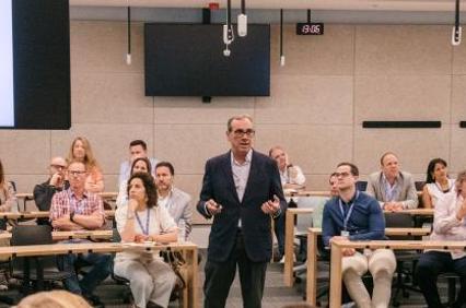 A speaker presents to an engaged audience in a conference setting.