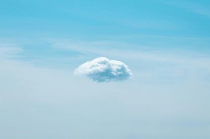 A single fluffy cloud isolated in a clear blue sky